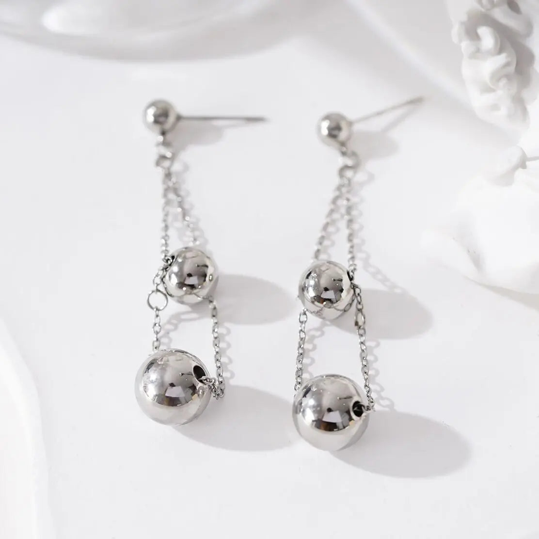 Boucles d'oreilles pendantes chaînes et double boules Eclat Paris