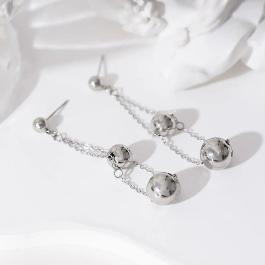 Boucles d'oreilles pendantes chaînes et double boules Eclat Paris